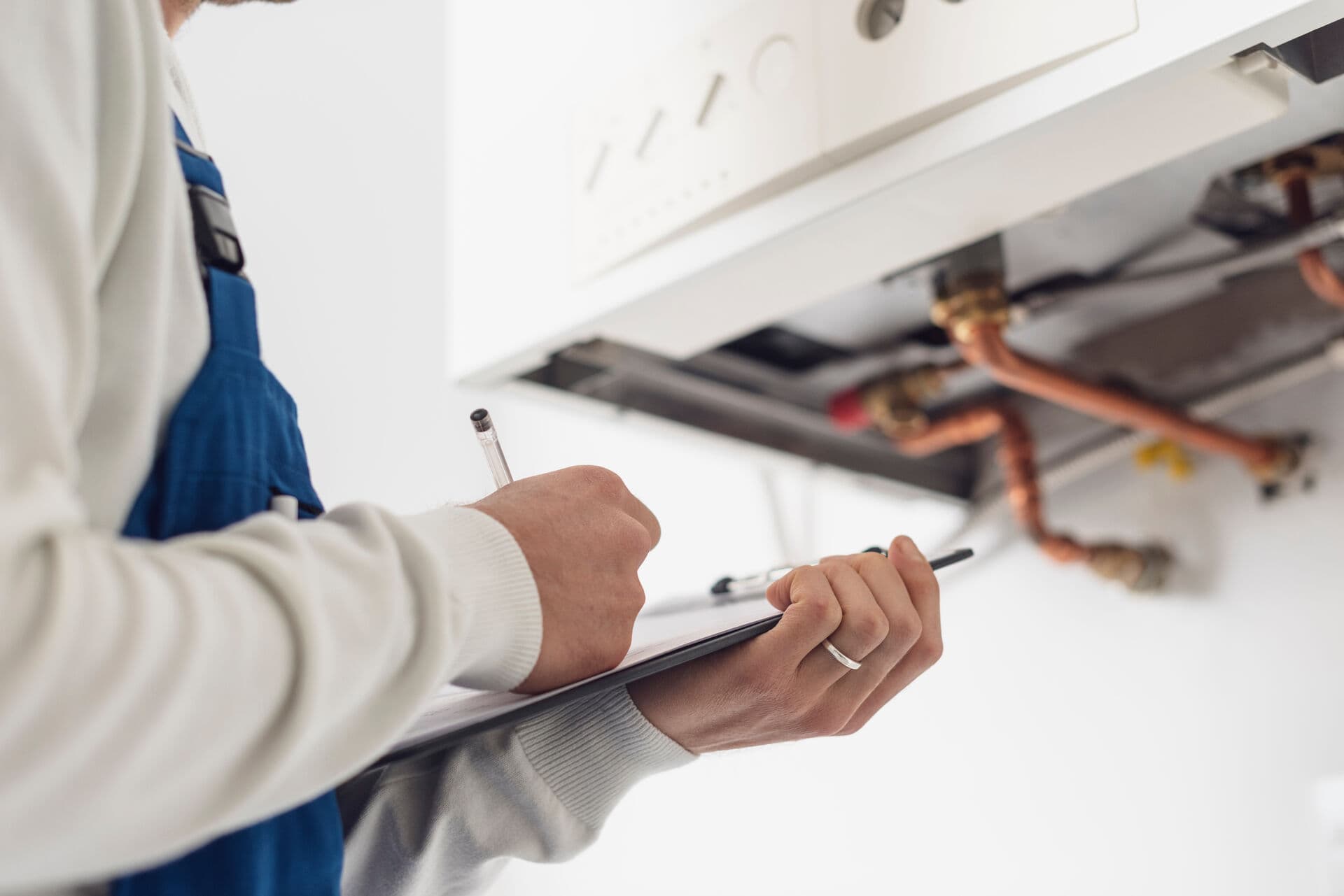Technician with clipboard inspecting water treatment equipment for upgrade